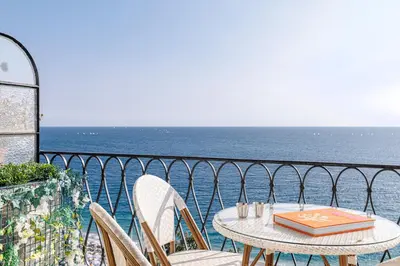 a table and chairs on a balcony overlooking the ocean at Outstanding View on the Promenade - Awesome 2 Bdr in Nice