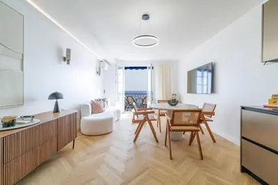 a kitchen and living room with a table and chairs at Outstanding View on the Promenade - Awesome 2 Bdr in Nice