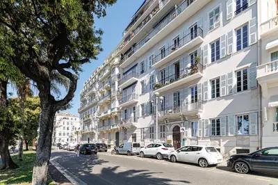 a large white building with cars parked on the street at Outstanding View on the Promenade - Awesome 2 Bdr in Nice