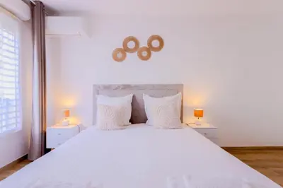 a bedroom with a large white bed with two lamps at Peaceful apartment in Nice with terrace, parking in Nice