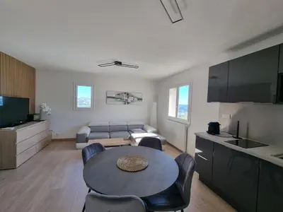 a living room with a table and a couch at 2 pièces avec jardin vue mer in Saint-Laurent-du-Var
