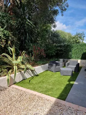 a garden with benches and grass in a yard at 2 pièces avec jardin vue mer in Saint-Laurent-du-Var