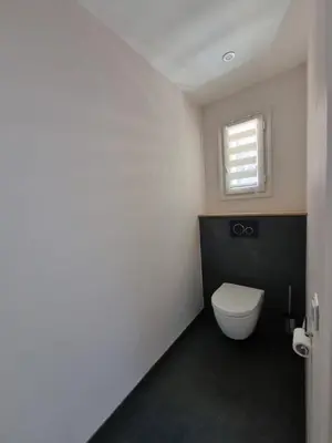 a bathroom with a white toilet and a window at 2 pièces avec jardin vue mer in Saint-Laurent-du-Var