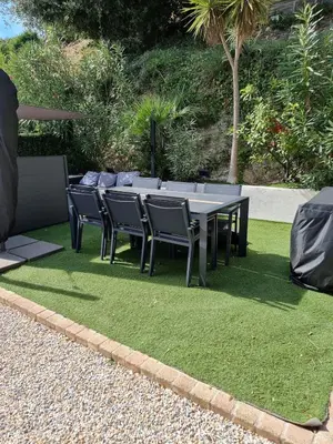 a table and chairs sitting on a patch of grass at 2 pièces avec jardin vue mer in Saint-Laurent-du-Var