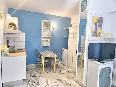 a kitchen with a table and a tv in a room at Nice Studio proche mer in Nice