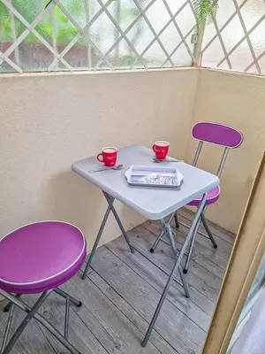 a table with two purple chairs and two cups on it at Nice Studio proche mer in Nice
