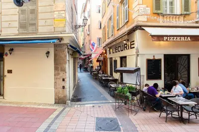 a street with people sitting at tables in an alley at #36 Bright Eagle Nest Old town 5 mins from sea AC Wifi in Nice
