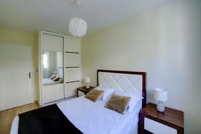 a bedroom with a large white bed with two pillows at Appartement luxueux entier 3 chambres in Nice