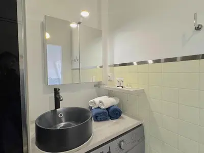 a bathroom with a sink and a mirror and towels at ⁂ Petit nid design au centre de Nice in Nice