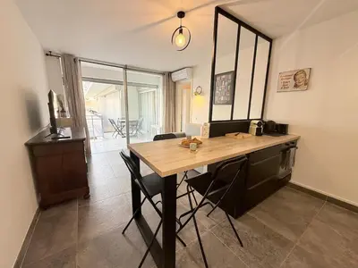 a kitchen with a wooden table and chairs in a room at Spacieux 3 pièces Gambetta, proche Tramway in Nice