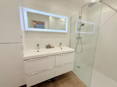 a white bathroom with a sink and a shower at Spacieux 3 pièces Gambetta, proche Tramway in Nice
