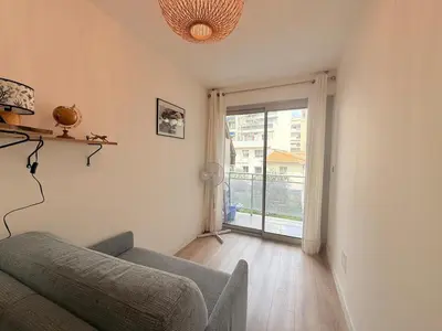 a living room with a couch and a large window at Spacieux 3 pièces Gambetta, proche Tramway in Nice