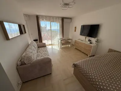 a kitchen with white cabinets and a washer and dryer at Le Cocon in Nice