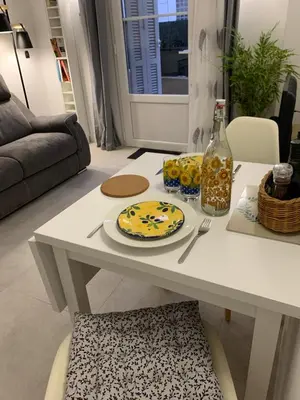 a table in a living room with a plate and a bottle at Élégant T2 au calme in Nice