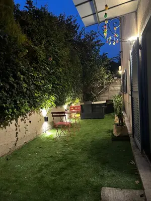 a house with a yard with a tree and an umbrella at Two rooms with 30 m2 garden in villa in Cagnes-sur-Mer