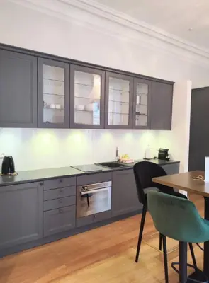 a kitchen with gray cabinets and a table and chairs at Studio in the heart of Nice close to amenities in Nice