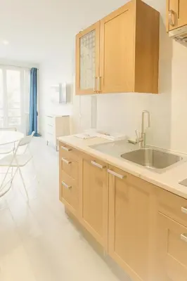 a kitchen with wooden cabinets and a sink at Stella Monte 1 AC WiFi 4 Pers in Nice