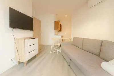 a living room with a couch and a tv and a table at Stella Monte 1 AC WiFi 4 Pers in Nice