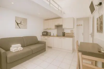 a living room with a couch and a kitchen at Le Carré D'or 2 Pers Centrale WiFi AC in Nice
