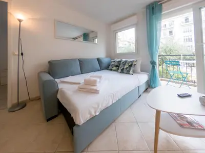 a bedroom with a bed and a table at Le Soleil D'or 4 Pers Parking WiFi in Nice