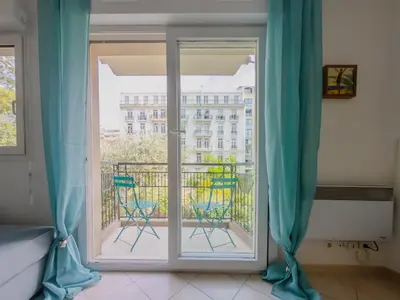 a room with a door open to a balcony with chairs at Le Soleil D'or 4 Pers Parking WiFi in Nice