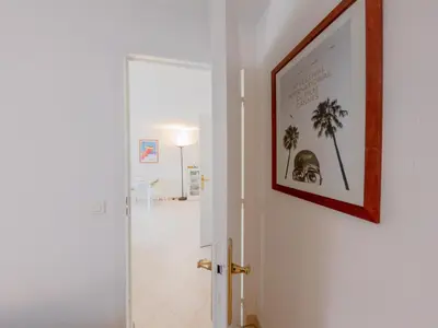 a hallway with a picture of palm trees on the wall at Le Soleil D'or 4 Pers Parking WiFi in Nice