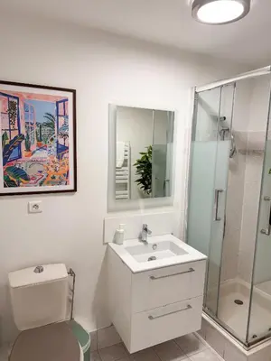 a white bathroom with a sink and a shower at Le Soleil D'or 4 Pers Parking WiFi in Nice