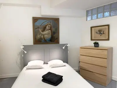 a bedroom with a bed with a painting on the wall at Appartement à 100 m de la mer avec stationnement gratuit in Nice