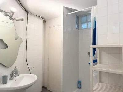 a white bathroom with a sink and a shower at Appartement à 100 m de la mer avec stationnement gratuit in Nice