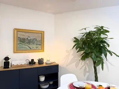 a dining room with a table and a plant at Appartement à 100 m de la mer avec stationnement gratuit in Nice