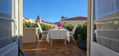 a table with a white table cloth on a balcony at Le grand Escurial in Nice