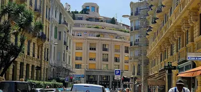 a street with buildings and cars on a city street at Le grand Escurial in Nice
