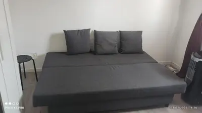 a bed with grey pillows in a room at chambre en colocation appartement partagé moyenne durée 1 in Nice