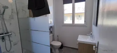 a bathroom with a toilet and a sink and a window at chambre en colocation appartement partagé moyenne durée 1 in Nice