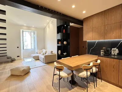 a kitchen and dining room with a wooden table and chairs at Duplex design - Old Town 50 m from the sea in Villefranche-sur-Mer