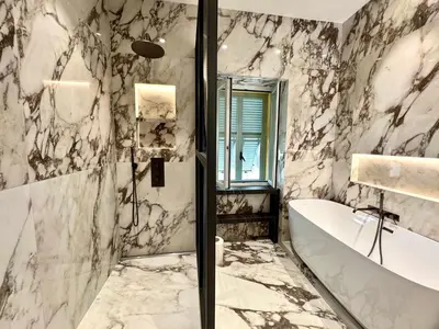 a bathroom with a tub and a marble wall at Duplex design - Old Town 50 m from the sea in Villefranche-sur-Mer