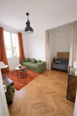 a living room with a green couch and a bed at Joli appartement central, tout équipé & proche gare in Nice