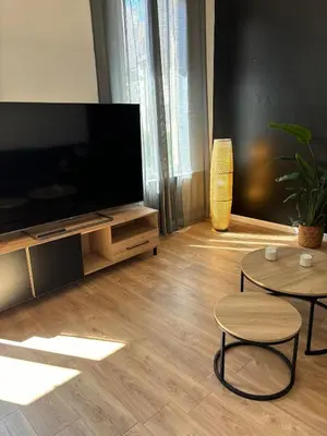 a living room with a flat screen tv and two tables at Apartment in Nice