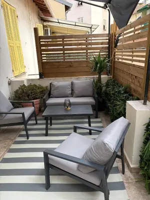 a patio with a couch and a table and chairs at Apartment in Nice