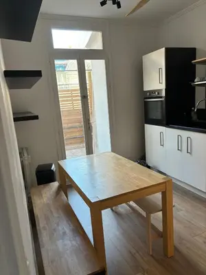 a kitchen with a wooden table in a room at Apartment in Nice