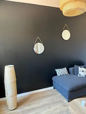 a living room with a blue couch and a mirror at Apartment in Nice