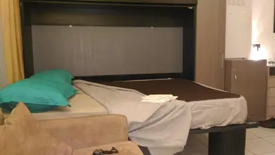a bed in a room next to a couch at Californie Appartement in Nice