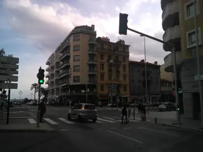 a green traffic light on a city street with buildings at Californie Appartement in Nice
