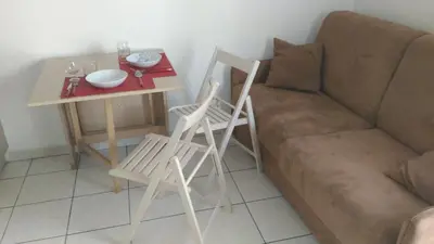 a living room with a couch and a table and chairs at Californie Appartement in Nice