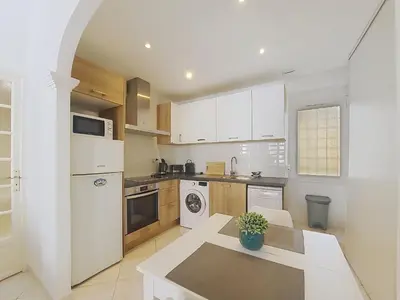 a kitchen with white cabinets and a table in it at Nestor&Jeeves - BELA VISTA - Central - Close sea in Nice