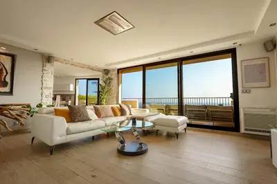 a living room with a couch and a table at Appartment - Panoramic Sea View - Swimming Pool in Villefranche-sur-Mer