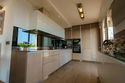 a large kitchen with wooden floors and stainless steel appliances at Appartment - Panoramic Sea View - Swimming Pool in Villefranche-sur-Mer