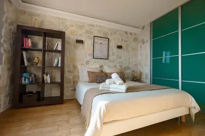 a bedroom with a bed and a book shelf at Appartment - Panoramic Sea View - Swimming Pool in Villefranche-sur-Mer