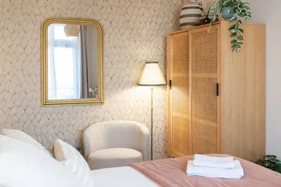 a bedroom with a bed and a mirror and a chair at L10 Suite Clemenceau Central, next train station in Nice