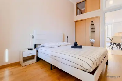 a white bedroom with a bed with a lamp on it at Nice acropolis 3 pièces proche du centre in Nice